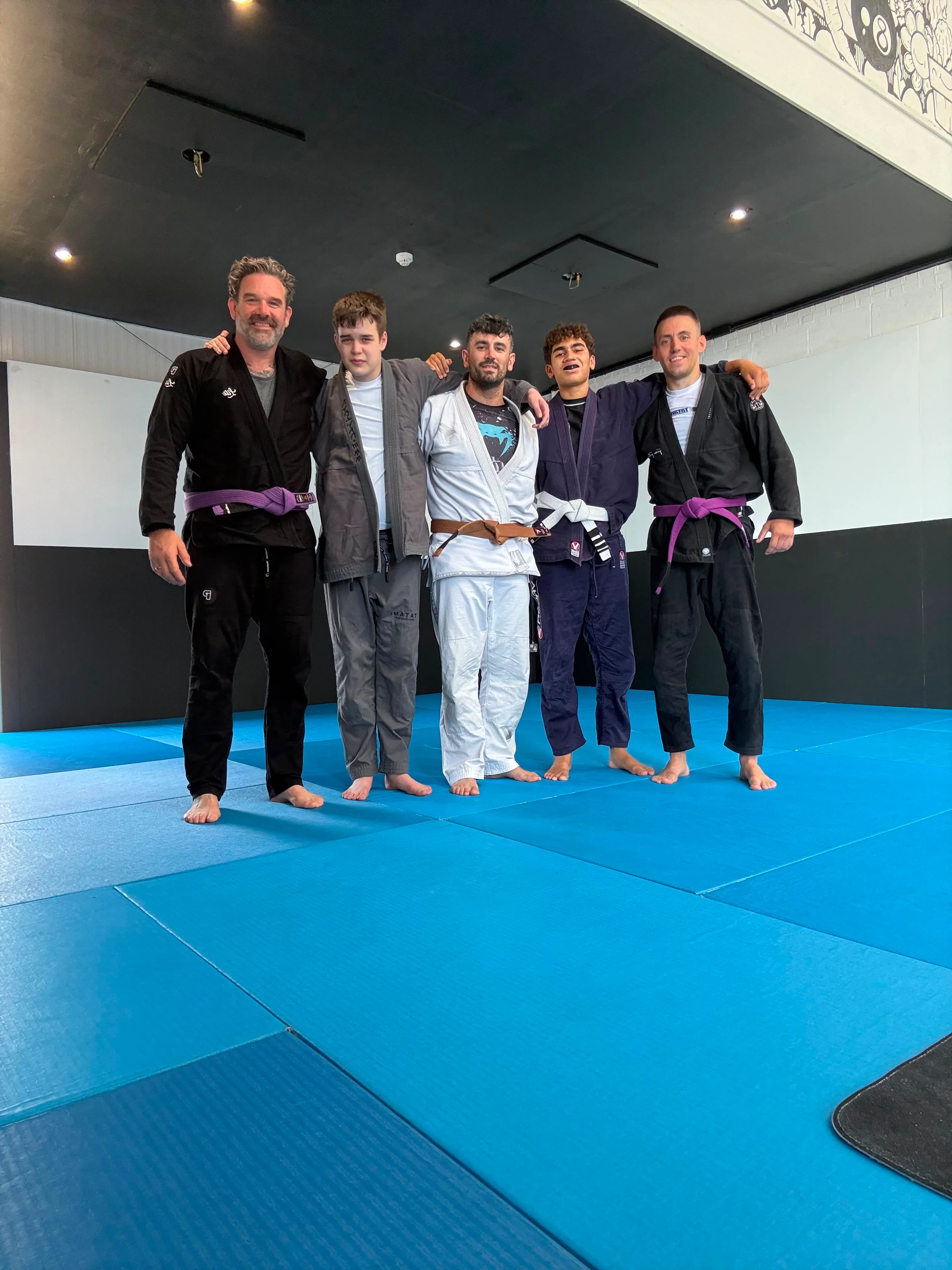 Five members in gis together after a morning gi class at Rebel Combat Sports, Eastbourne