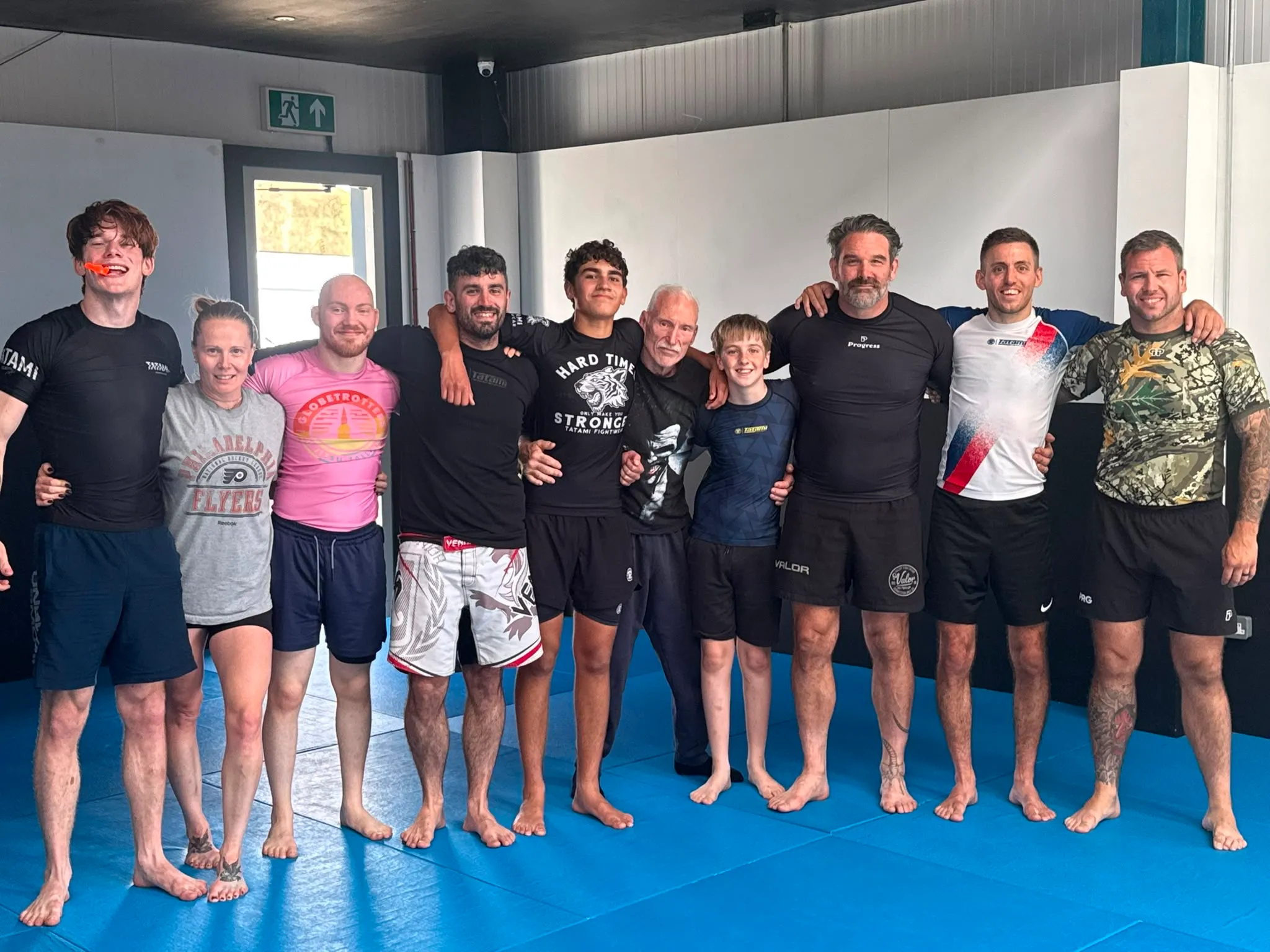 Rebel members of mixed ages — teenagers, women and men, beginners and experienced grapplers — together after a daytime session